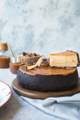 Slice of cheesecake with caramel sauce, concrete background, closeup view. Salted caramel sauce poured on cheesecake