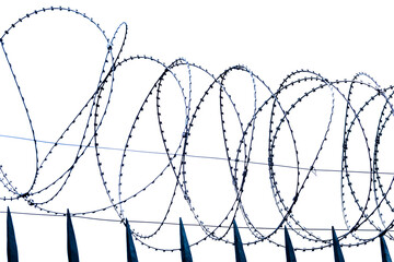 Barbed wire border. Metal barbed wire on grey sky background.