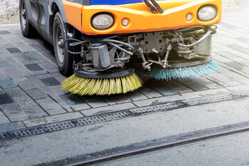 Close up of a truck cleaning a street. Street sweeper machine.