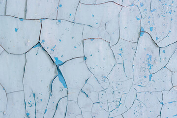 Peeling paint on the wall. Old concrete wall with cracked flaking paint. Weathered rough painted...