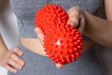 Double red back massage ball with spikes in hand. - 485046654