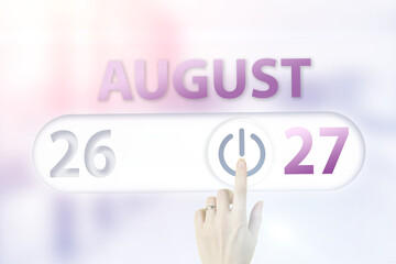 August 27th. Day 27 of month, Calendar date.Hand finger switches pointing calendar date on sunlight office background. Summer month, day of the year concept.