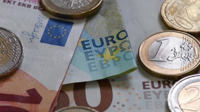 Argent liquide de la zone euro : détail de divers billets de banque et pièces de monnaie. Gros plan avec le mot "euro", le drapeau de l'UE, ainsi que des pièces de 50 cents, 1 et 2 euros