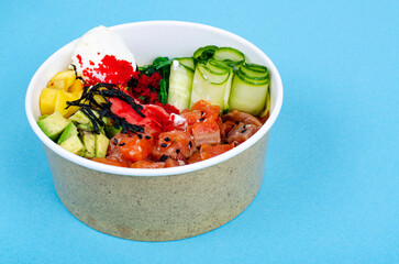 Poke with sea food and vegetables on blue background. Studio Photo
