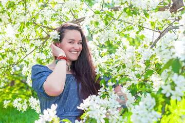 Happy brunette woman in blooming garden