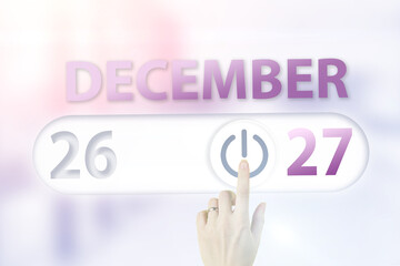December 27th. Day 27 of month, Calendar date.Hand finger switches pointing calendar date on sunlight office background. Winter month, day of the year concept.