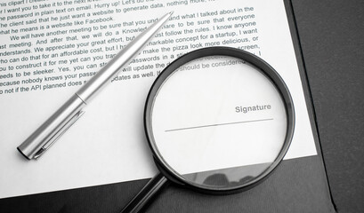 Signaure line in contract with pen and magnifying glass