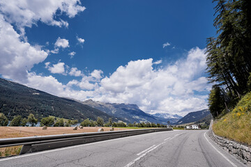 Asphalt road in Alps mountains. Road trip concept.