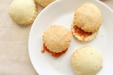 Scones with strawberry jam on a white plate.  Flat lay top view photo.  Food from above concept. 