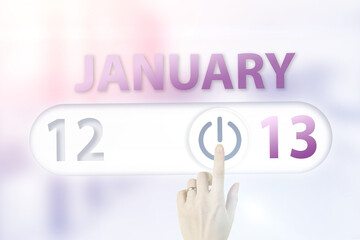 January 13rd. Day 13 of month, Calendar date.Hand finger switches pointing calendar date on sunlight office background. Winter month, day of the year concept.