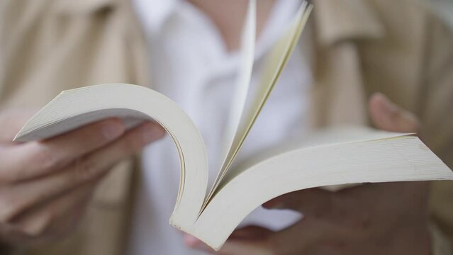 Close up Man Reading a book on hand holds a book. Selective focus. 4K