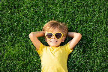 Happy child playing outdoor in spring park - obrazy, fototapety, plakaty