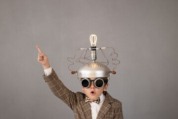 Smart child wearing funny helmet with illuminated lightbulb - 485052038