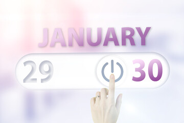 January 30th. Day 30 of month, Calendar date.Hand finger switches pointing calendar date on sunlight office background. Winter month, day of the year concept.