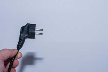 plug held oblique in one hand save electricity left view with gray