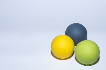three different colored balls for massage on gray