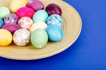 Obraz na płótnie Canvas Decorated handmade Easter eggs for the holiday season on blue background. Creative minimal abstract concept. Studio Photo