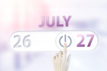 July 27th. Day 27 of month, Calendar date.Hand finger switches pointing calendar date on sunlight office background. Summer month, day of the year concept.