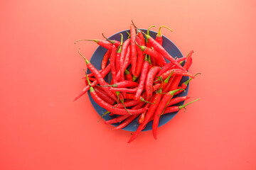 Fototapeta premium red chili pepper on a plate on red background 