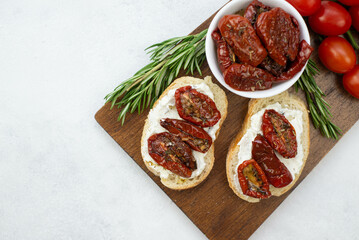 two sandwiches with cream cheese and sun dried tomatoes on the wooden.