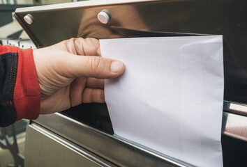 hand putting mail in mailbox
