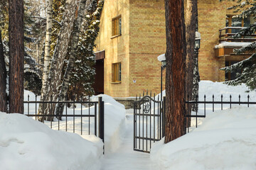 Entrance to the courtyard of a private house. Snowy winter. Outdoors