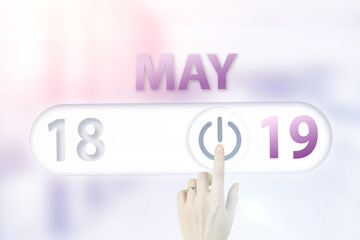 May 19th. Day 19 of month, Calendar date.Hand finger switches pointing calendar date on sunlight office background. Spring month, day of the year concept.