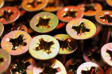 Anodized screw caps close-up. A vivid illustration on the theme of hardware and fasteners. Materials for construction and repair. Self drilling screws. Macro
