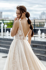 bride in wedding dress near the fountain in the city center