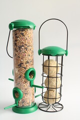Generic Bird feeders, one bird feeder filled with seed and the other bird feeder filled with fat balls isolated on plain background - 485057052