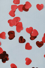 Red paper heart confetti on the white background on Valentine's Day
