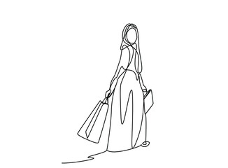 happy woman in muslim dress walking with shopping bags in hands