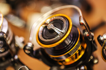 Spinning reel spool coated with titanium nitride. Fragment of the friction mechanism and line...
