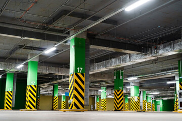 Large underground car park overlooking a ceiling illuminated by LED lights and concrete columns...