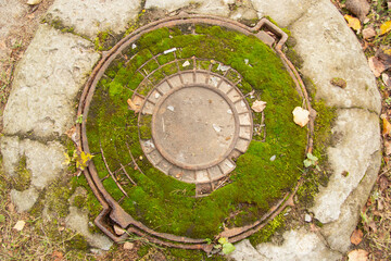 old rusty hatch cover. in summer Moss grows on it