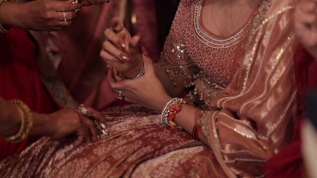 A Shot of an Indian Bride wearing a gold bangle as a part of her Bridal Jewellery at her Indian Wedding in New Delhi,India
