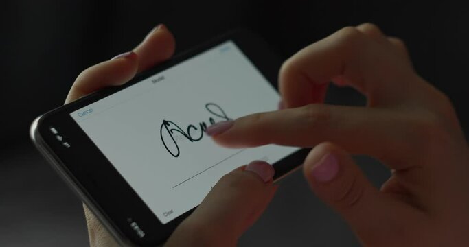 Digital signature on mobile screen by finger. Woman hand. Close-up