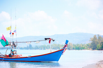Naklejka na ściany i meble Travel by Thailand. Landscape with traditional longtail fishing boat on the sea surface.