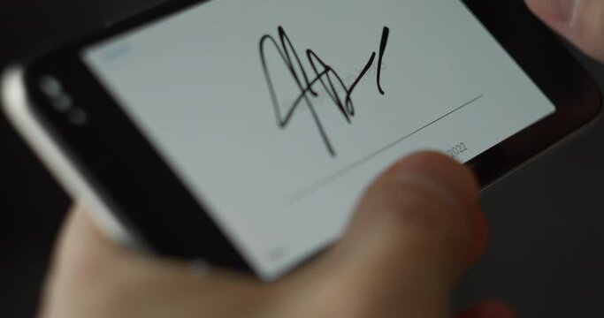 Man signing a contract on a smartphone screen. Close-up