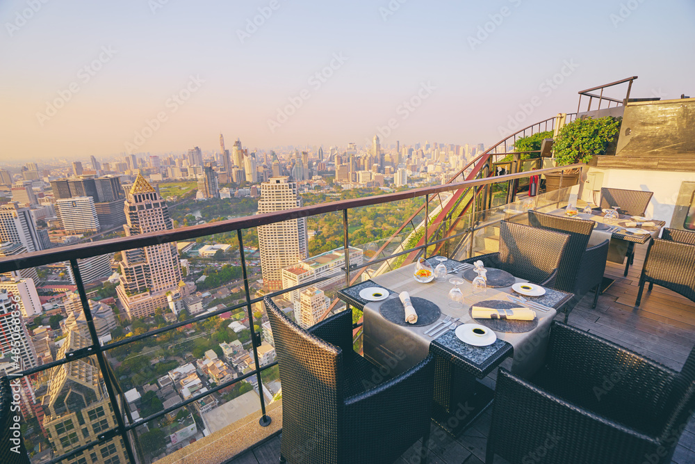 Sticker table setting on roof top restaurant with megapolis view, bangkok thailand.