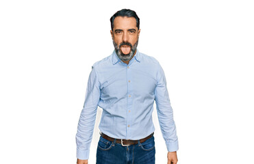 Fototapeta premium Middle aged man with beard wearing business shirt sticking tongue out happy with funny expression. emotion concept.