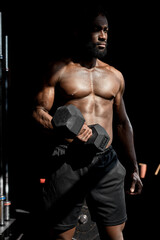 Fototapeta na wymiar strong african athletic men pumping up muscles workout bodybuilding concept. handsome bodybuilder man doing exercises with dumbbell in gym, with naked torso fitness and bodybuilding workout