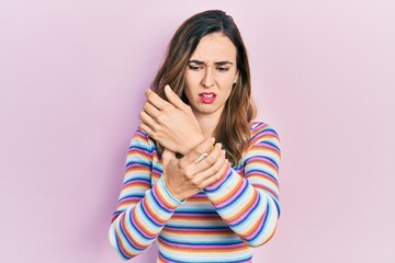 Young hispanic girl wearing casual clothes suffering pain on hands and fingers, arthritis...
