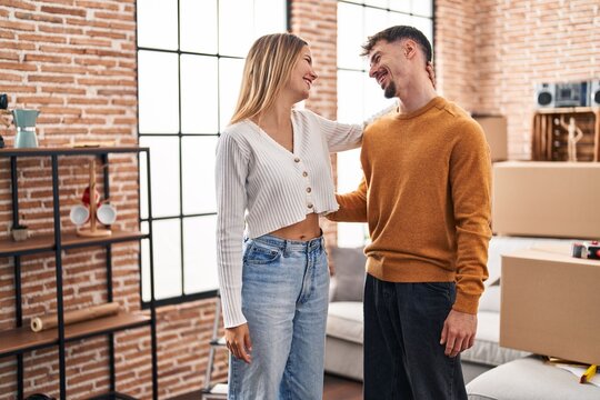 Young man and woman couple smiling confident standing together at new home