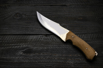 Carving knife, on a dark wooden background. Knife on a cutting board.