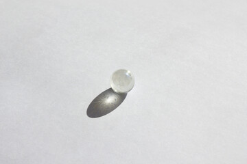 Clear glass bead reflect light on the white background.