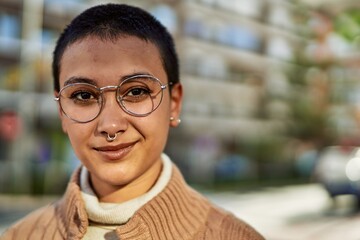 Beautiful hispanic woman with short hair smiling happy outdoors