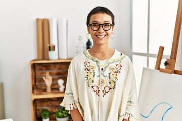 Young hispanic woman with short hair at art studio with a happy and cool smile on face. lucky person. © Krakenimages.com