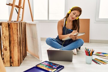 Young hispanic artist woman smiling happy drawing at art studio.