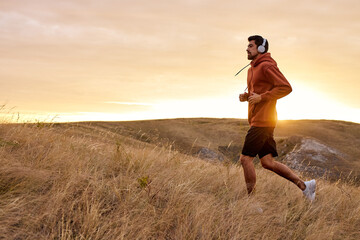 fitness runner man running on field training for marathon alone, run doing high intensity interval...